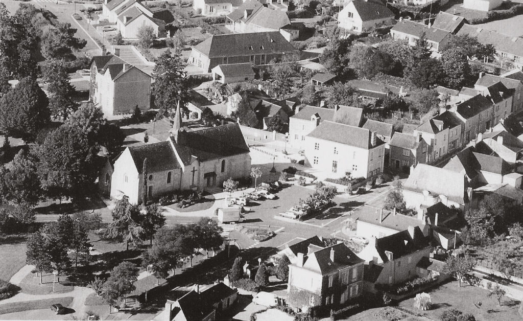 Vue du centre-bourg de Beaucouzé en 1998. En premier plan, l'église et son parking et l'ancienne mairie.